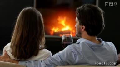 幸福的夫妇在壁炉旁碰杯